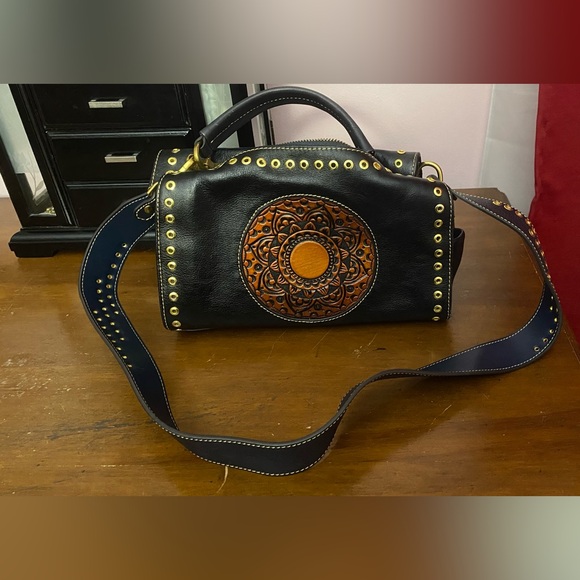 Black leather cross body purse with orange colored medallion on front. - Picture 3 of 14
